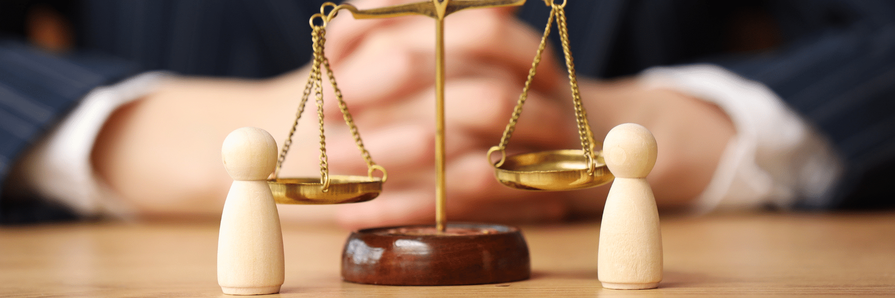 Scales of justice with wooden figures to represent Estate Litigation Attorneys in North Carolina