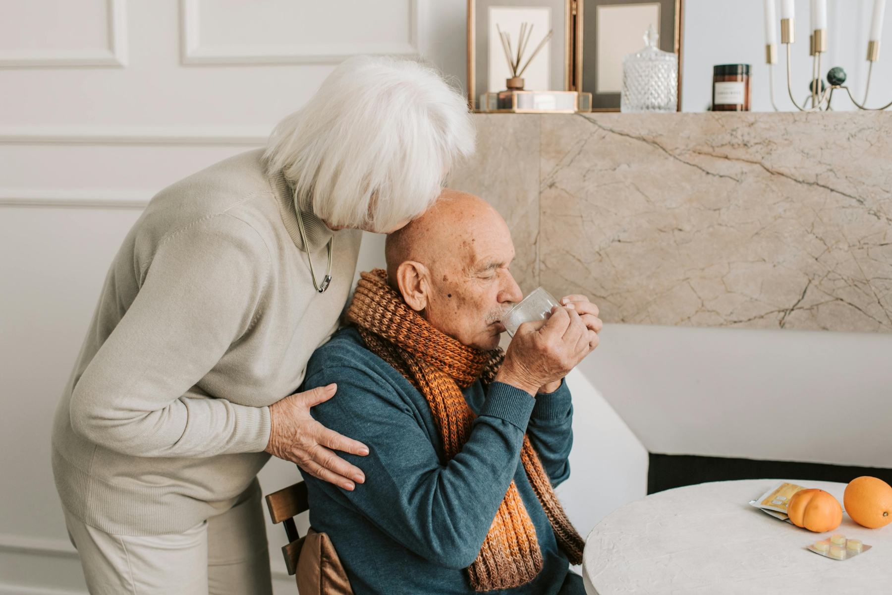 Image of a loving wife kissing her incapacitated husband on the head while he finished his breakfast. This illustrates the duty of care for power of attorney in north carolina.